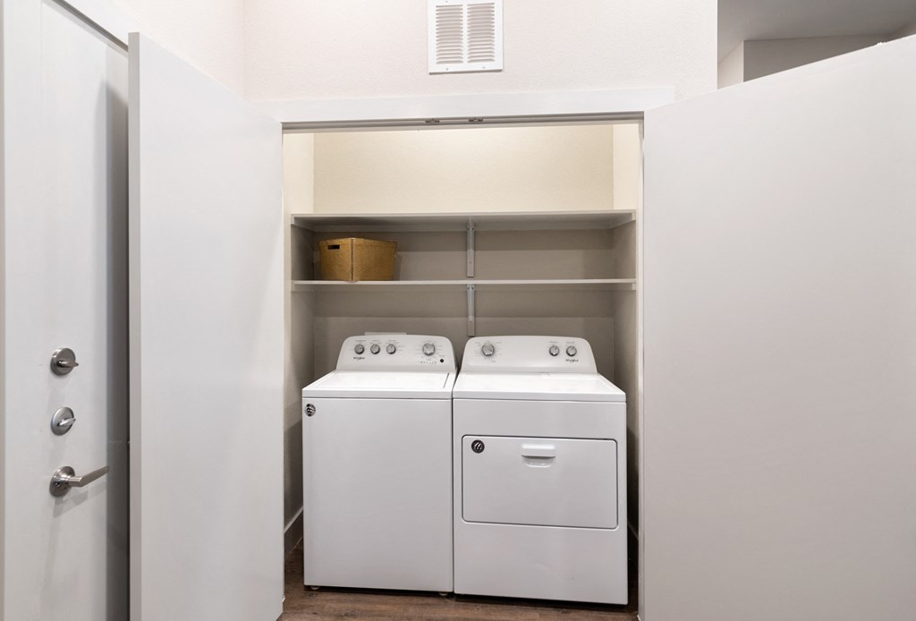 a small laundry room with a washer and dryer in it and a door