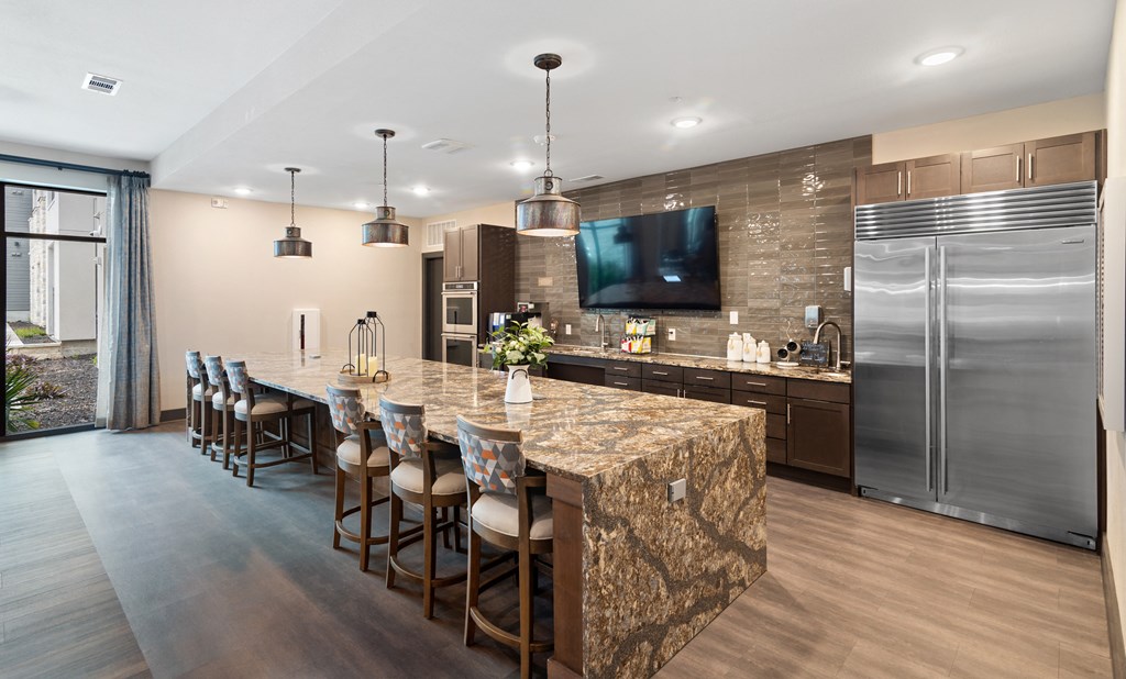 a kitchen with stainless steel appliances and a large island with chairs