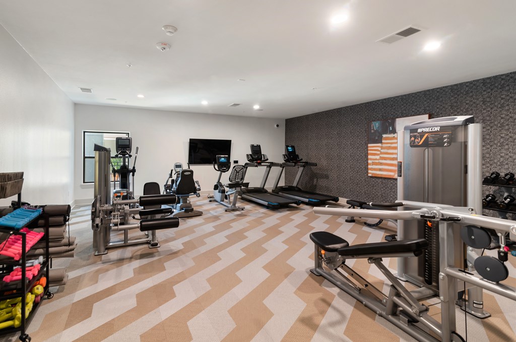 A well-equipped gym with a variety of machines and weights.