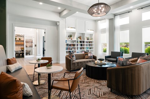A living room with a white table and brown chairs.