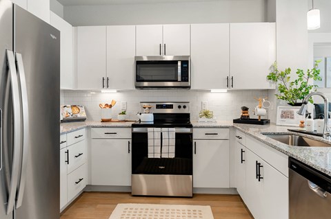 a white kitchen with stainless steel appliances and white cabinets