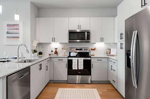 a kitchen with white cabinets and stainless steel appliances