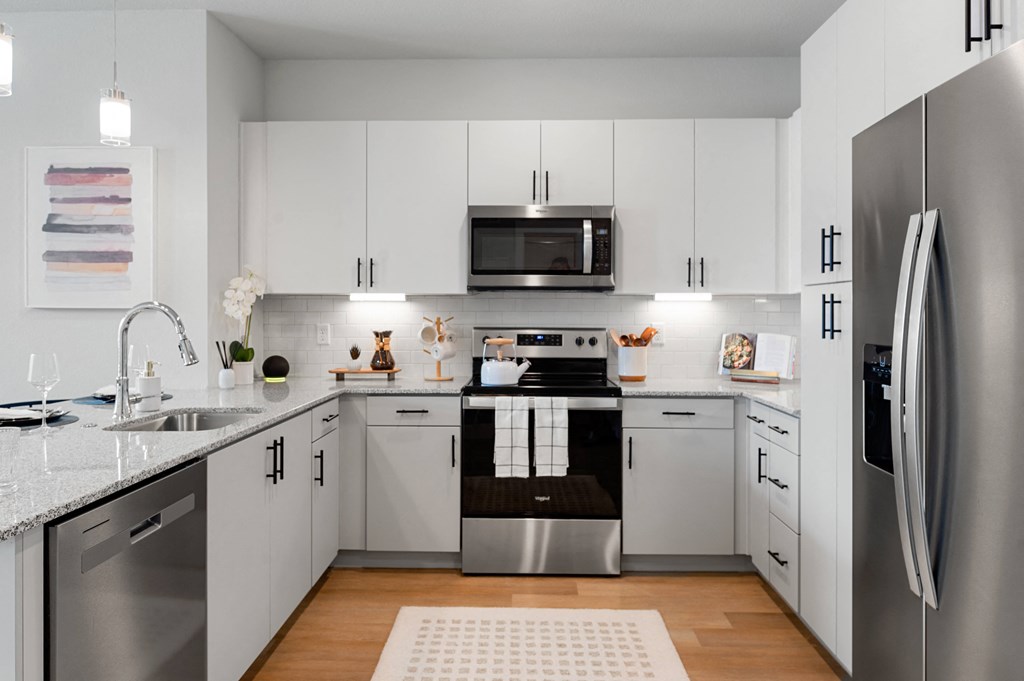 a kitchen with white cabinets and stainless steel appliances