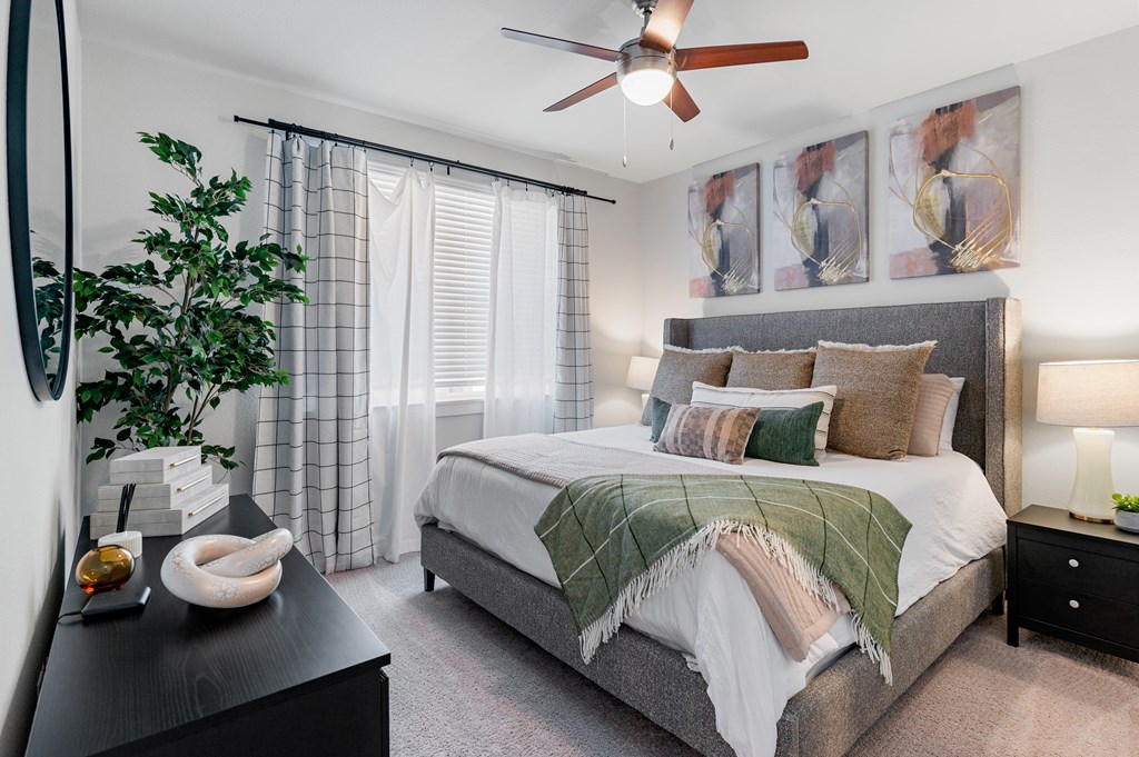a bedroom with a large bed and a ceiling fan