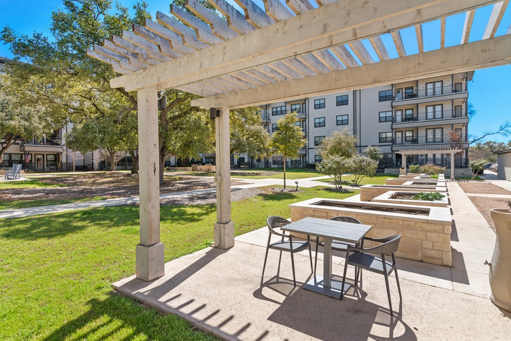 a patio with a table and chairs under a pergola
