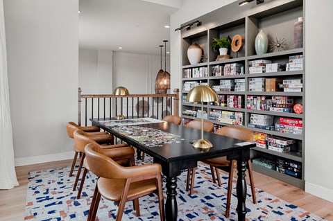 a dining room with a table and chairs and a bookshelf