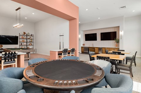 a clubhouse with a round table with chairs and a television