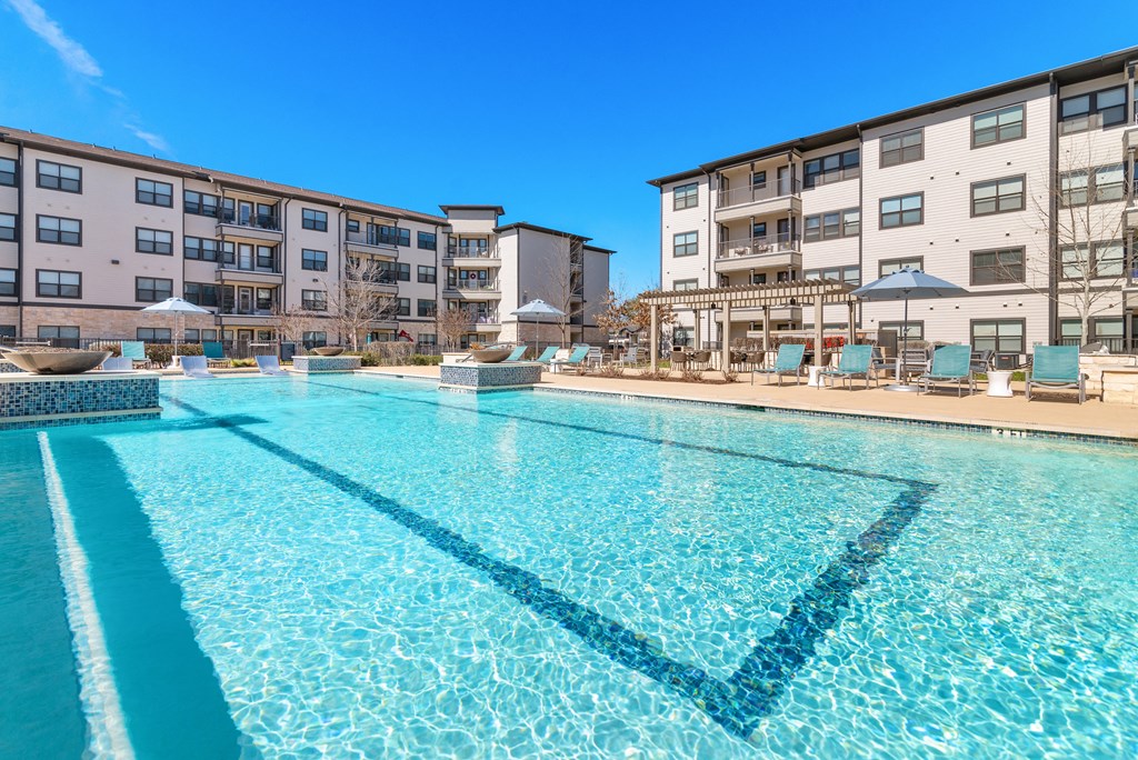 a swimming pool with an apartment building in the background