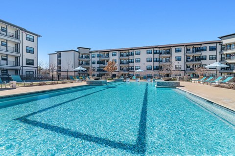 a swimming pool with an apartment building in the background
