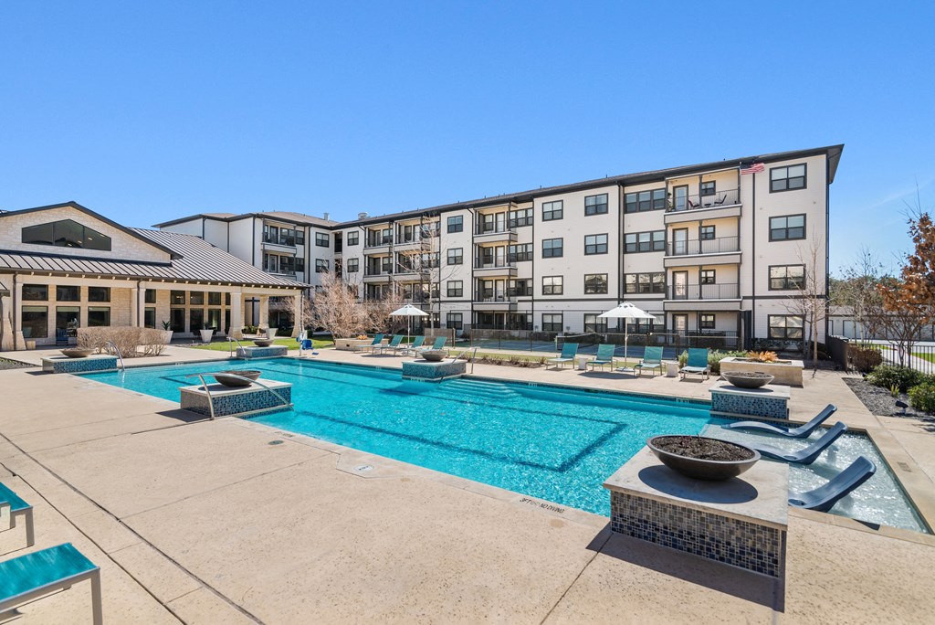 a swimming pool with an apartment building in the background