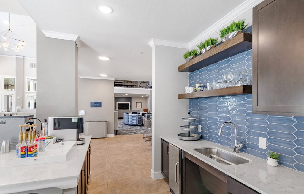 a kitchen with a sink and a blue tile wall