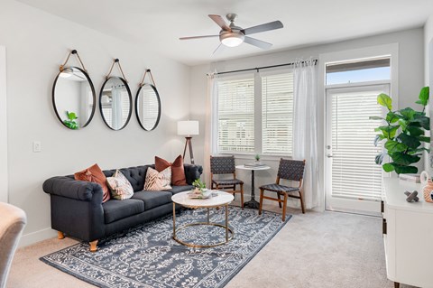 a living room with a couch and a table and a ceiling fan