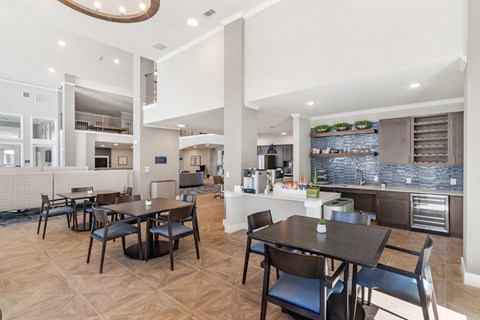 a communal clubhouse dining room opening up to a kitchen at a senior apartment community
