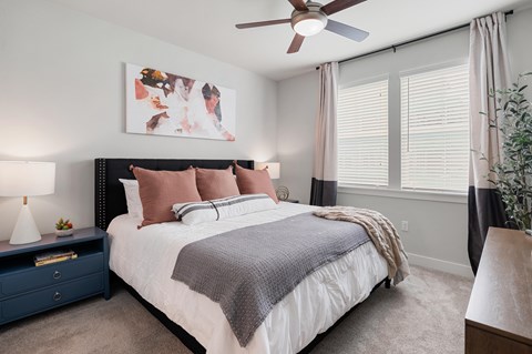 a bedroom with a bed and a ceiling fan
