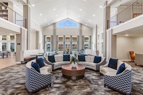 a large lobby with vaulted ceilings and sitting areas at a senior apartment community