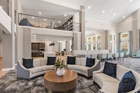a lobby sitting area with a balcony sitting area in the background at a senior apartment community