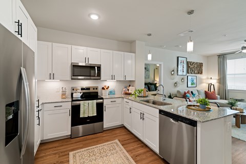 A modern kitchen with white cabinets and stainless steel appliances.