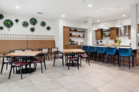 the dining area of a restaurant with tables and chairs and a kitchen
