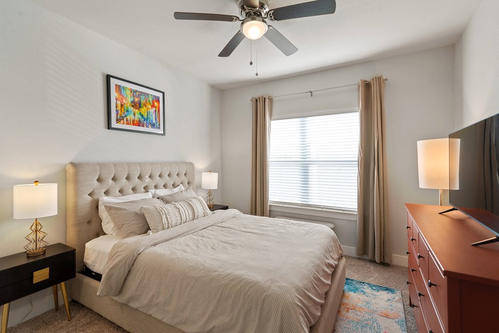 a bedroom with a large bed and a ceiling fan