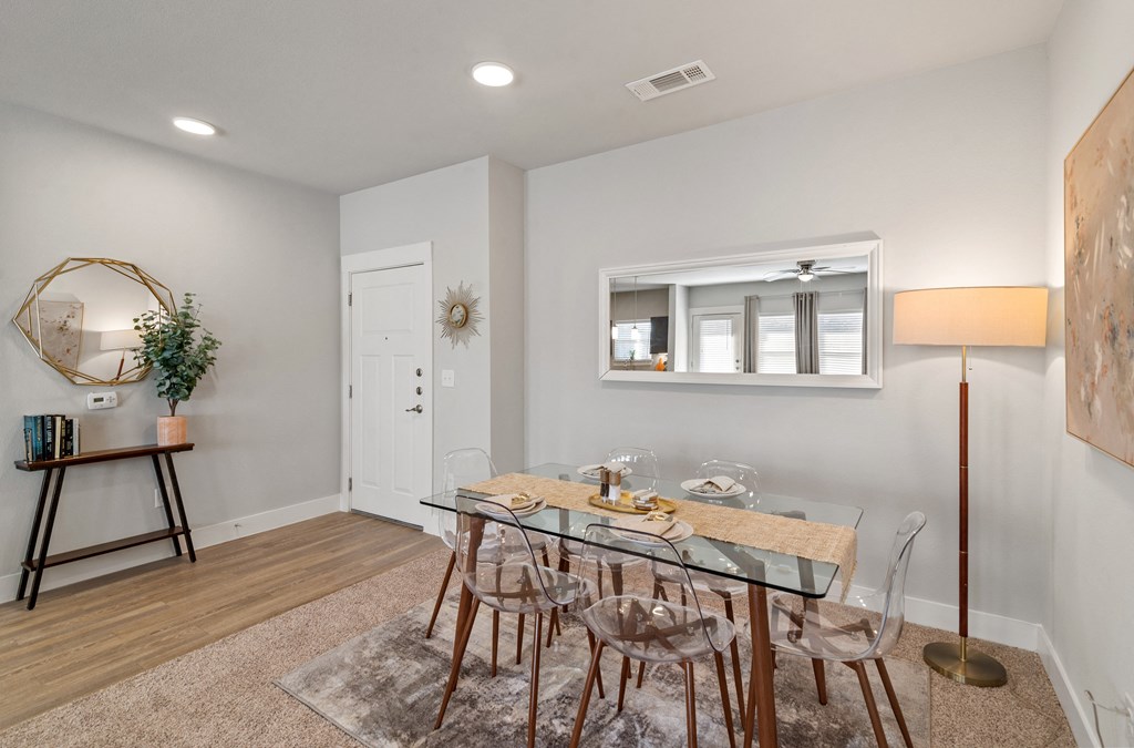 a dining room with a glass table and chairs