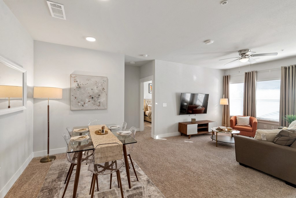 an open living room with a dining room table and chairs and a television