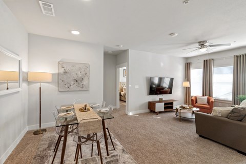 an open living room with a dining room table and chairs and a television