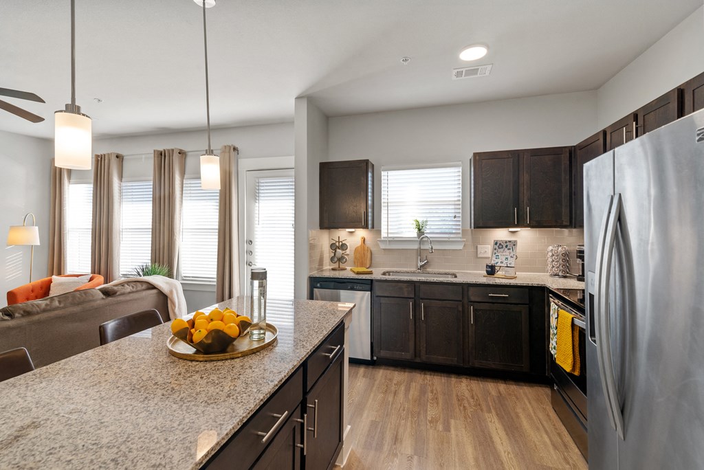 an open kitchen and living room with a large island with fruit on it