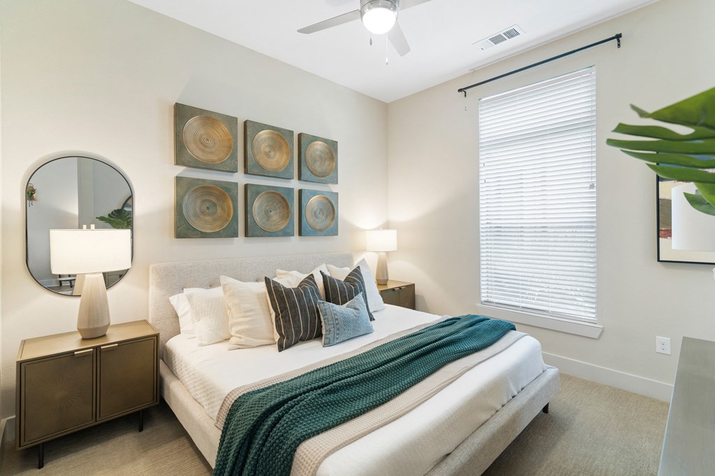 a king size bed in a bedroom with a ceiling fan at a senior apartment community