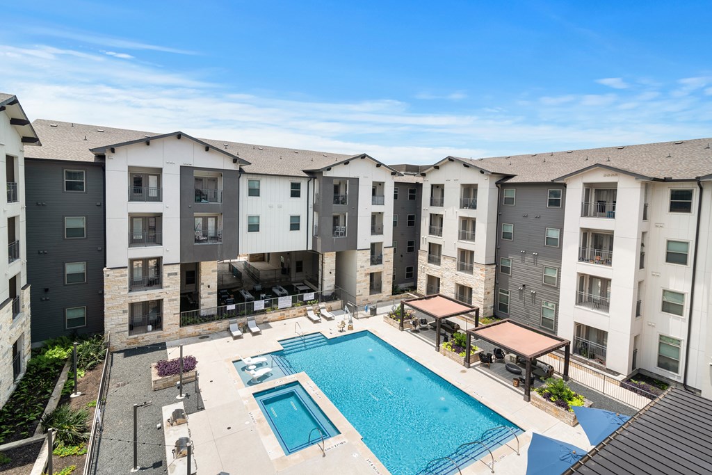 an aerial view of resort-style pool with lounge chairs at a senior apartment community