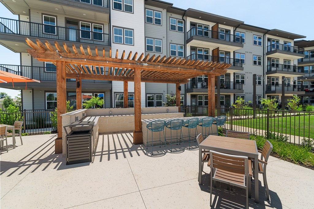 an outdoor patio with tables and chairs and an apartment building