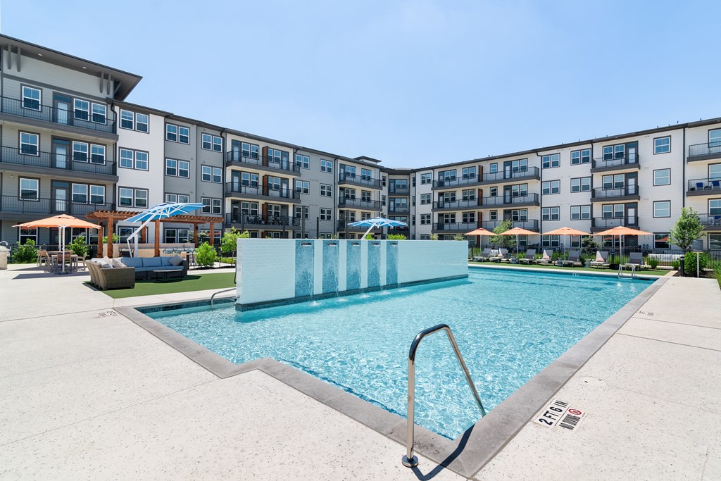 a swimming pool with an apartment building in the background