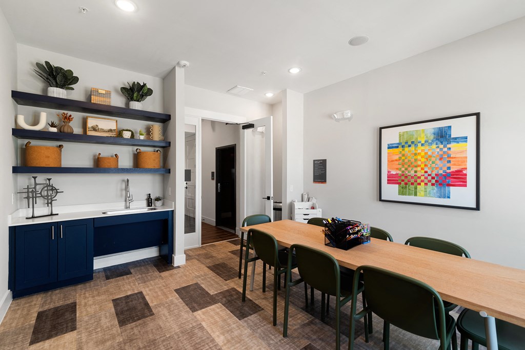 a dining room with a wooden table and chairs and a kitchen with blue cabinets