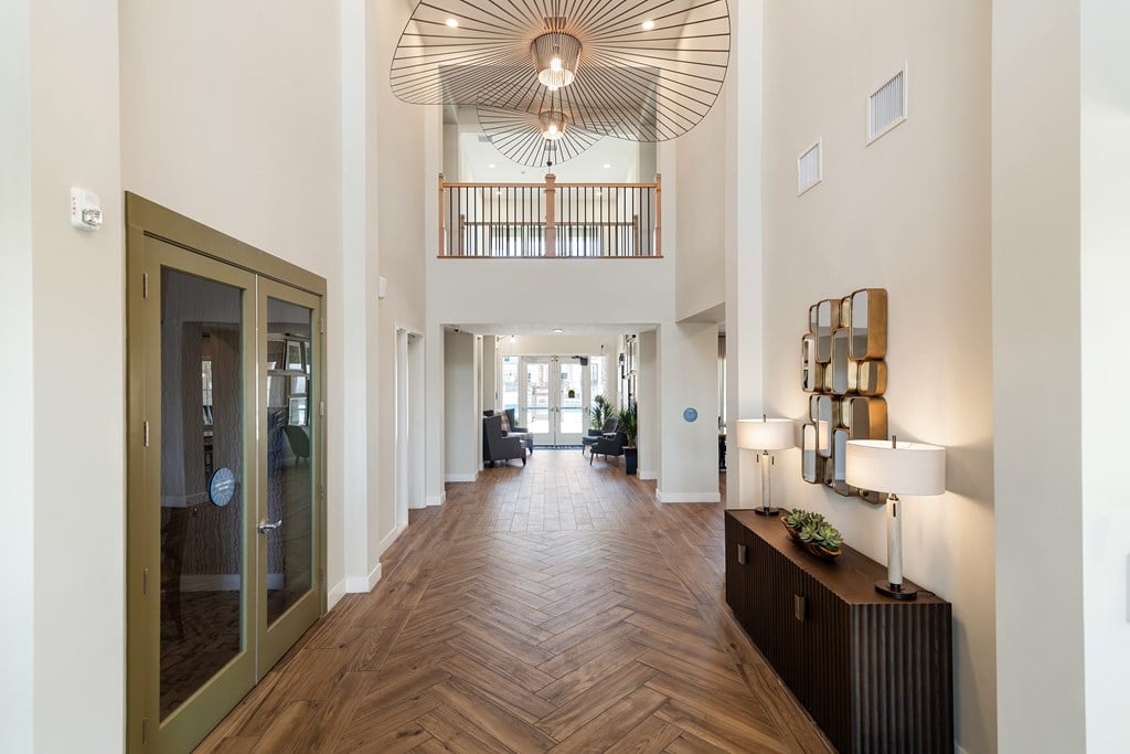 A hallway with a wooden floor and a ceiling fan.