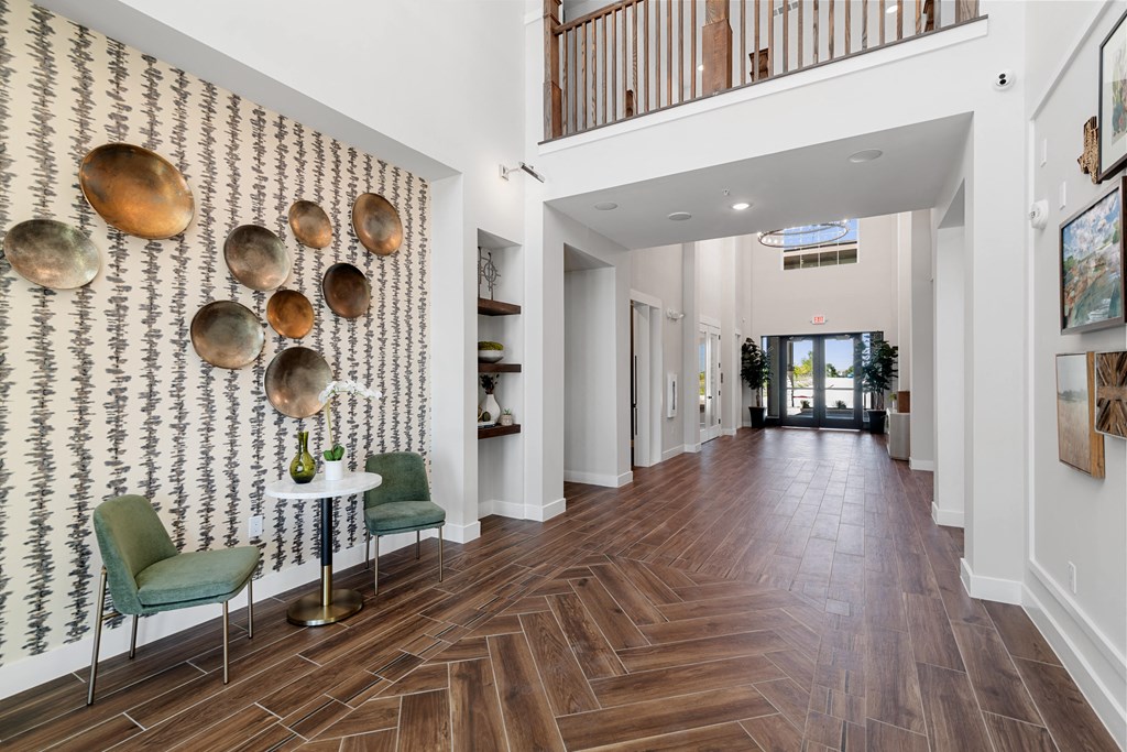 a long hallway with chairs and a wall with metal pans on it