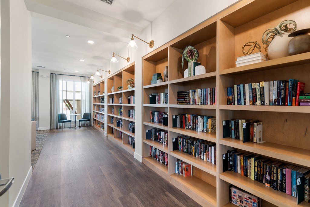 A long bookshelf filled with books in a room.