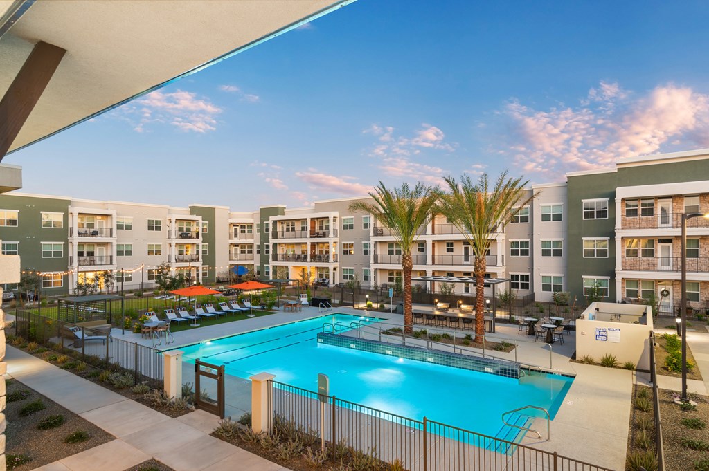 A swimming pool in front of apartment buildings.
