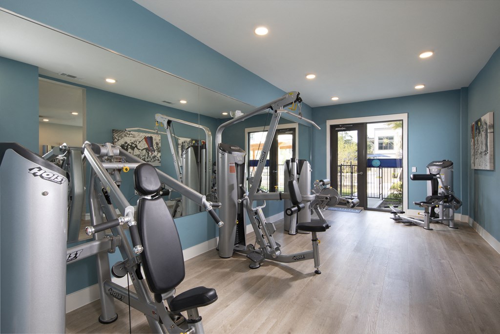 a gym with fitness machines at a senior apartment community