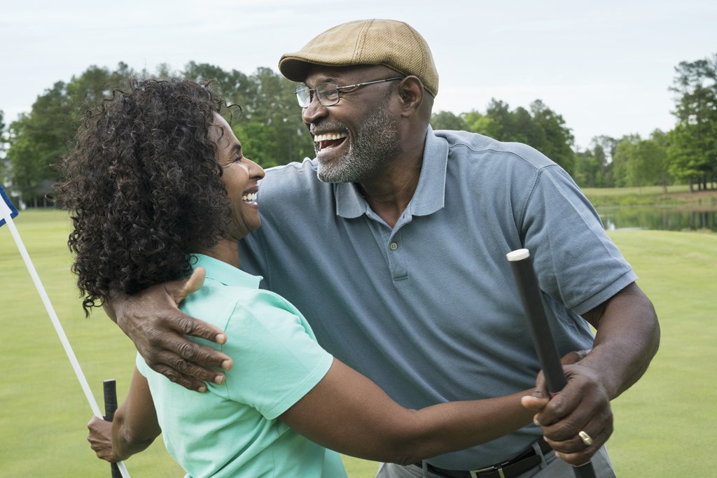 a man and a woman laughing on a golf course