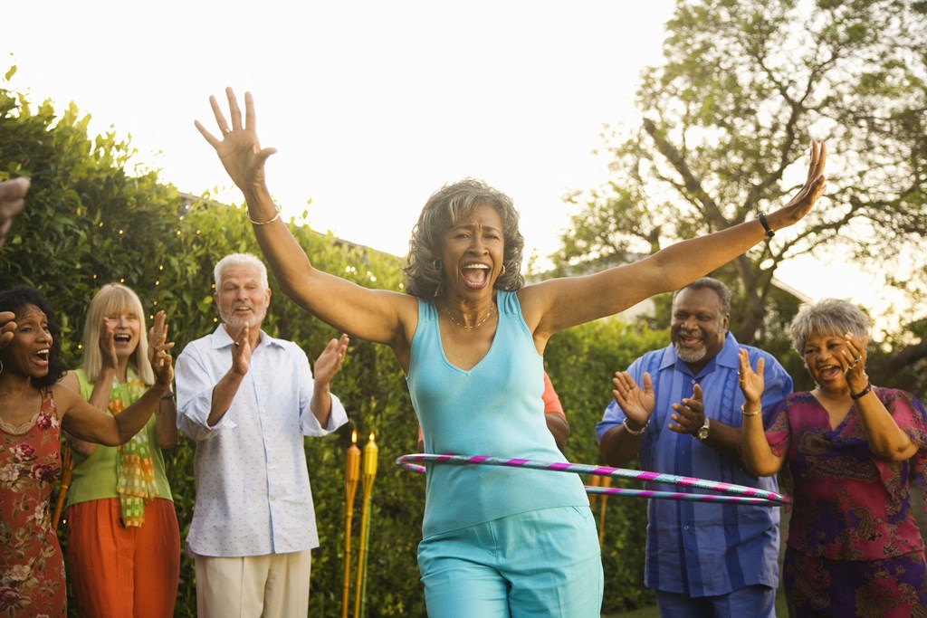 a group of people playing with hula hoops at a senior apartment community