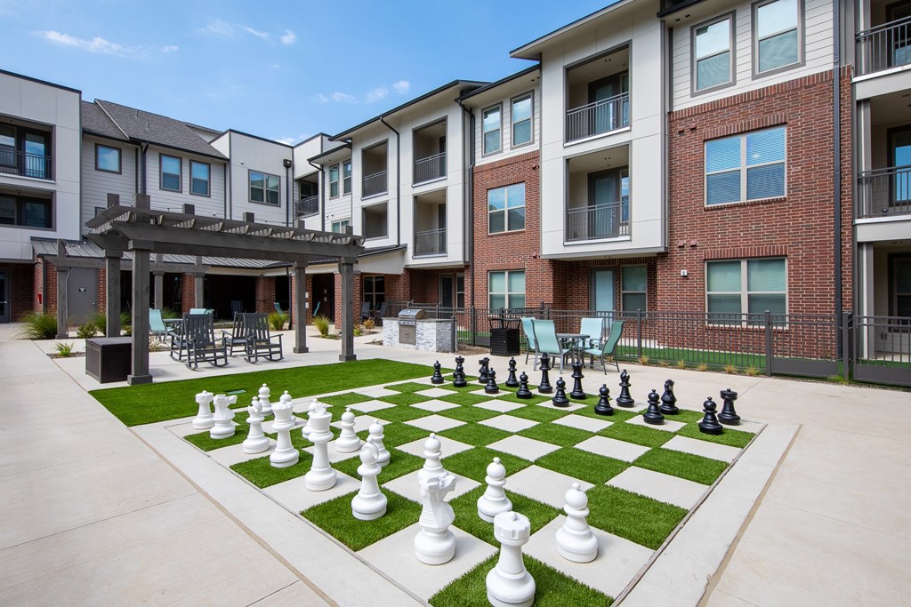 a giant lawn chess set at a senior apartment community