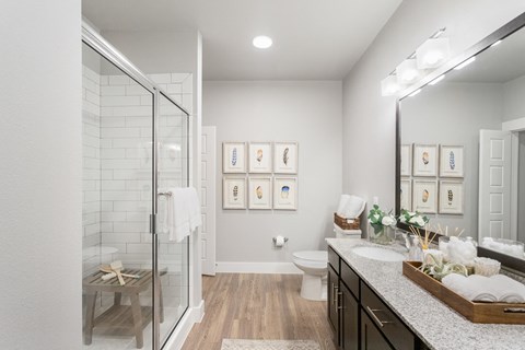 a bathroom with two sinks and a shower at a senior apartment community