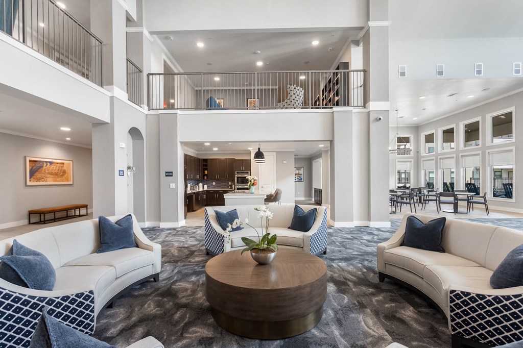 a lobby with a big seating area and tall ceilings at a senior apartment community