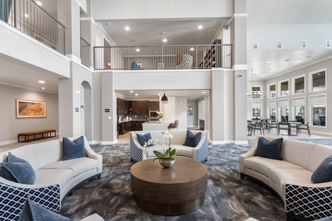 a lobby with a big seating area and tall ceilings at a senior apartment community