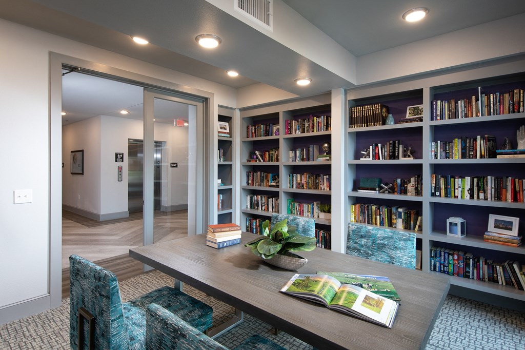 a library with a table and chairs and bookshelves