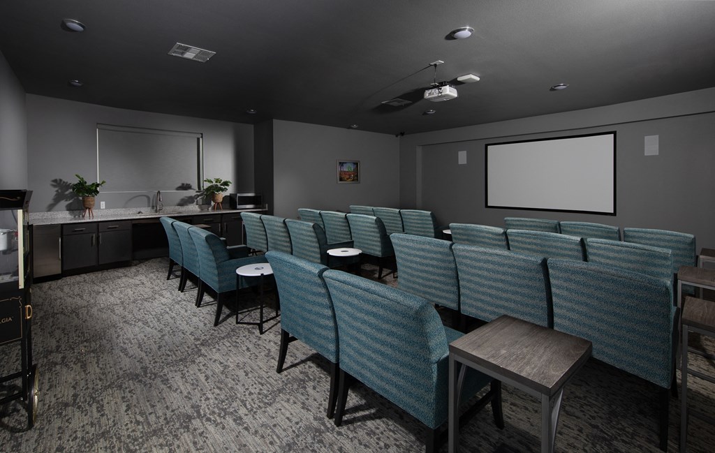 a conference room with blue chairs and a projector screen