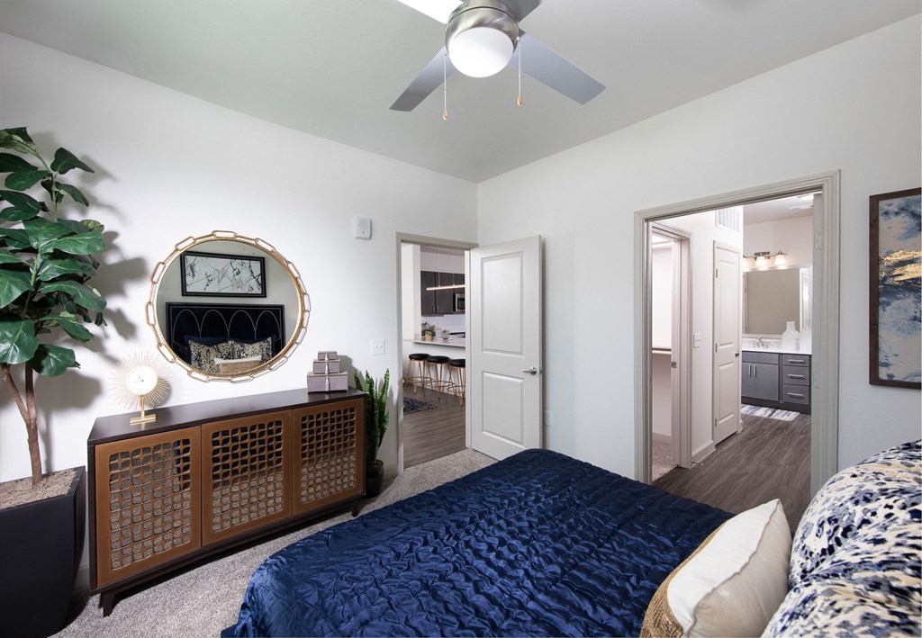 a bedroom with a blue bed and a ceiling fan