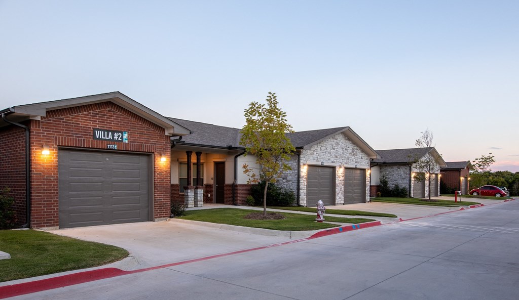 a row of houses with garages and street lights