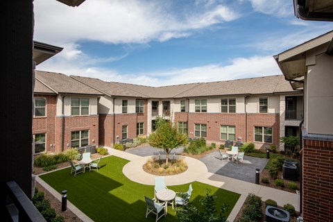 a courtyard with tables and chairs at a senior apartment community