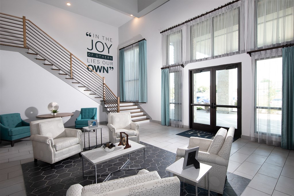 a living room with white furniture and a staircase