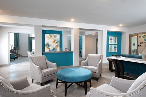 a living room with white chairs and a blue bar and a pool table